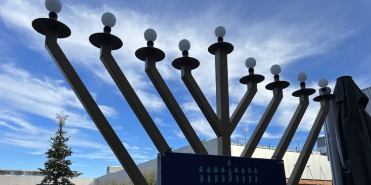 Outdoor menorah display during Hanukkah celebration with a Christmas tree in the background at City Center Bishop Ranch, San Ramon, California, on Dec. 13, 2023.