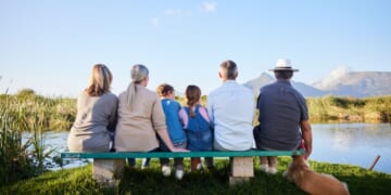 A family looking at a scenic view while sitting together in a nature reserve.