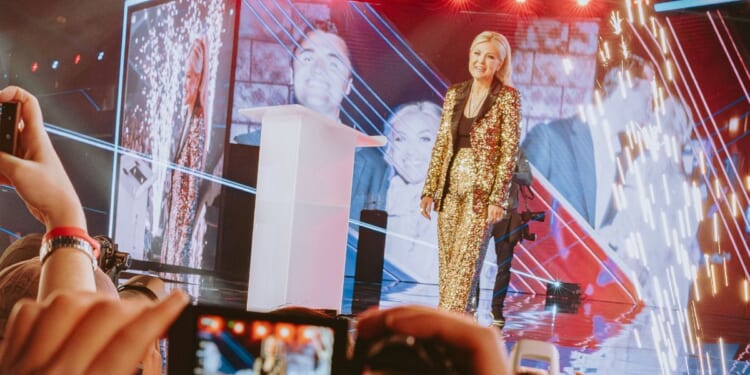 Turning Point USA CEO Erika Kirk walks onstage at AmericaFest in Phoenix, Arizona, on Dec. 18, 2025.