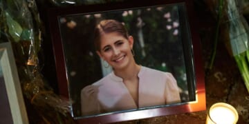 Candles are lit by a framed photo of mass shooting victim Ella Cook at a makeshift memorial near Brown University in Providence, Rhode Island, on Dec. 15, 2025.