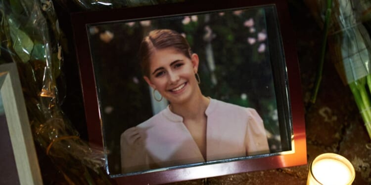 Candles are lit by a framed photo of mass shooting victim Ella Cook at a makeshift memorial near Brown University in Providence, Rhode Island, on Dec. 15, 2025.