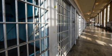 The sun shines on the bars in a prison.