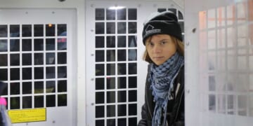 Greta Thunberg is arrested and sits in the back of a police van outside the offices of Aspen Insurance on Dec. 23, 2025, in London, England.