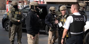 Border Patrol chief Greg Bovino speaks with a Chicago Police officer while searching for undocumented immigrants in a southwest side neighborhood on Nov. 6, 2025, in Chicago, Illinois.