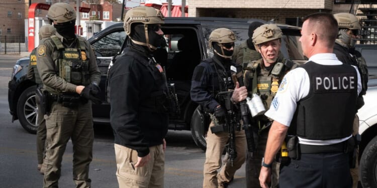 Border Patrol chief Greg Bovino speaks with a Chicago Police officer while searching for undocumented immigrants in a southwest side neighborhood on Nov. 6, 2025, in Chicago, Illinois.