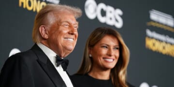 President Donald Trump grins as he attends the 48th annual Kennedy Center Honors on Dec. 7 in Washington with first lady Melania Trump.