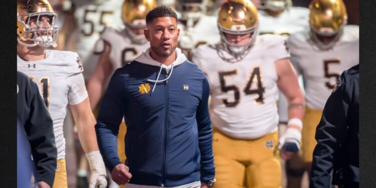 Head Coach Marcus Freeman of the Notre Dame Fighting Irish leads his team into the stadium Nov. 29 to start the second half of a college football game against the Stanford Cardinals in Palo Alto, California.