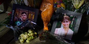 Framed photos of mass shooting victims Mukhammad Aziz Amurzokov and Ella Cook are seen Monday at a makeshift memorial near Brown University in Providence, Rhode Island.