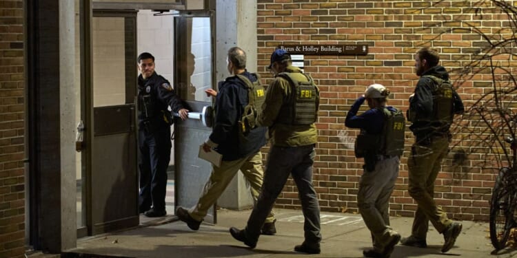 FBI agents enter the Barus and Holley building, home to the engineering and physics departments and the site of a mass shooting, at Brown University campus in Providence, Rhode Island, on Dec. 13, 2025.