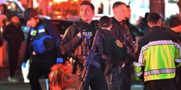 Law enforcement officials carrying weapons gather near Brown University in Providence, Rhode Island.