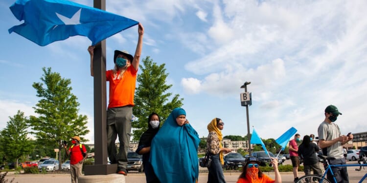 People hold up Somali flags during a protest calling for justice for Isak Aden on July 1, 2020 in Eagan, Minnesota. Isak Aden was killed on July 2, 2019 after a standoff with Eagan Police. No charges were brought against the officers involved in his death.