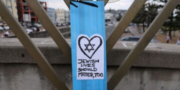 A note attached to a menorah is seen Sunday on a small bridge at Bondi Beach where gunmen stood during a mass shooting one week earlier in Sydney, Australia.