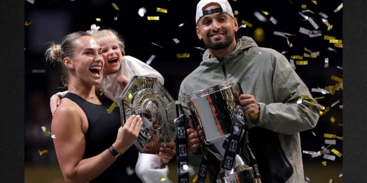 Runner-up Aryna Sabalenka and her goddaughter Nicole pose for a photo with Nick Kyrgios of Australia during the trophy ceremony following the Battle of the Sexes match between the two Sunday in Dubai, United Arab Emirates.