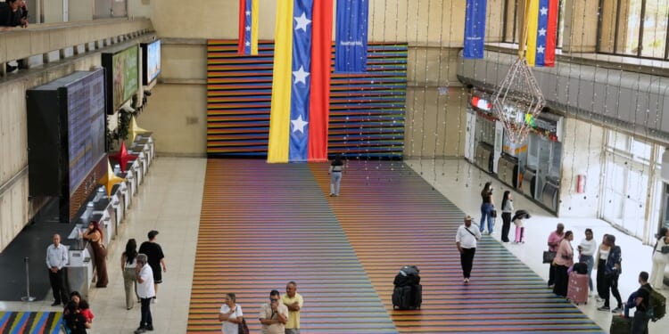 Travelers wait in the main hall of the Simon Bolivar Maiquetia International Airport in Maiquetia, Venezuela, on Nov. 23, 2025.