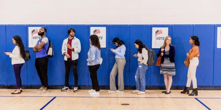 A group of voters stand in line at a community center so they can participate in early voting.