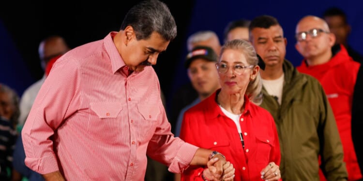 Venezuela's President Nicolas Maduro dances with his wife Cilia Flores during a demonstration for the swearing-in of Bolivarian committees in Caracas on November 15, 2025.