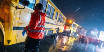 School buses drive through a storm in the Brooklyn borough of New York City on Jan. 9, 2024.