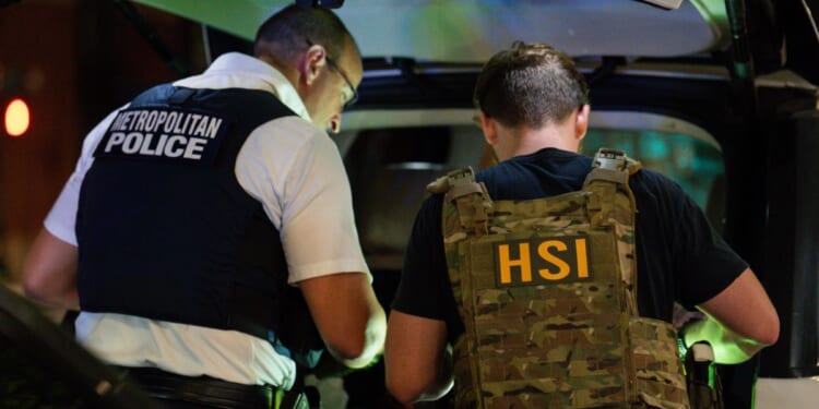 FBI, Metropolitan Police Department, Homeland Security Investigations, and Immigration and Customs Enforcement officers search the inside of a car during a traffic stop on Aug. 14, 2025, in Washington, D.C.