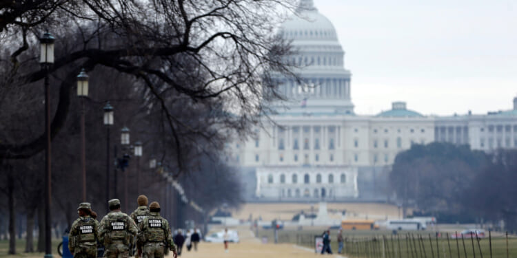 National Guard patrol the Washington Mall, with the U.S. Capitol in the background, on Jan. 9, 2026, in Washington, D.C.
