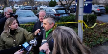 Multnomah County District Attorney Nathan Vasquez, center, speaks to the media Thursday following reports that federal immigration officers shot and wounded two vehicle occupants in Portland, Oregon.