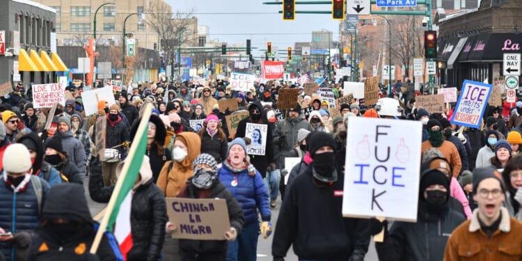 Protesters hold signs as they march from Powderhorn Park in Minneapolis against Immigration and Customs Enforcement and the fatal shooting of Renee Good by an ICE agent, calling on federal authorities to leave the city and demand accountability, in Minneapolis, Minnesota, on Jan. 10, 2026.