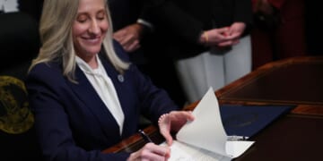 Virginia Governor Abigail Spanberger grins as she signs executive orders shortly after being sworn in as governor at the Virginia State Capitol in Richmond, Virginia, on Jan. 17, 2026.