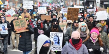 Protesters hold signs as they march from Powderhorn Park in Minneapolis against Immigration and Customs Enforcement and the fatal shooting of Renee Good by an ICE agent, calling on federal authorities to leave the city, in Minneapolis, Minnesota, on Jan. 10, 2026.