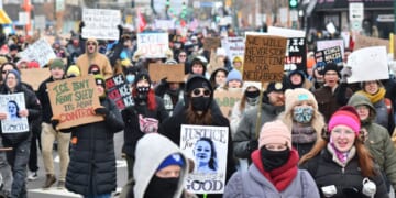 Protesters hold signs as they march from Powderhorn Park in Minneapolis against Immigration and Customs Enforcement and the fatal shooting of Renee Good by an ICE agent, calling on federal authorities to leave the city and demand accountability, in Minneapolis, Minnesota, on Jan. 10, 2026.