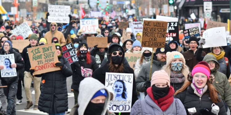 Protesters hold signs as they march from Powderhorn Park in Minneapolis against Immigration and Customs Enforcement and the fatal shooting of Renee Good by an ICE agent, calling on federal authorities to leave the city and demand accountability, in Minneapolis, Minnesota, on Jan. 10, 2026.