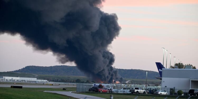 Fire and smoke mark where a UPS cargo plane crashed near Louisville Muhammad Ali International Airport on Nov. 4, 2025, in Louisville, Kentucky.