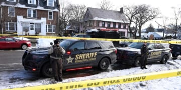 Members of the Hennepin County Sheriff's Office look on as people gather near the scene of a shooting Wednesday by an ICE agent during federal law enforcement operations in Minneapolis, Minnesota.