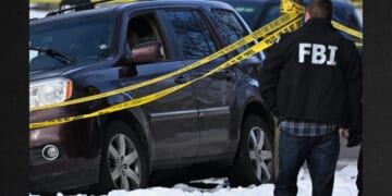 A bullet hole is seen in a windshield Wednesday as law enforcement officers attend to the scene of the shooting involving federal law enforcement agents in Minneapolis.