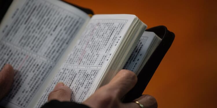 A worshipper holds a copy of the Bible while attending a church service ahead of Christmas in Hong Kong on Dec. 23, 2018, during which several members of the congregation wore black in support of underground churches in mainland China.