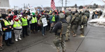 Federal agents stand watch as protestors gather outside the Bishop Henry Whipple Federal Building in Saint Paul, Minnesota, on Jan. 8, 2026.