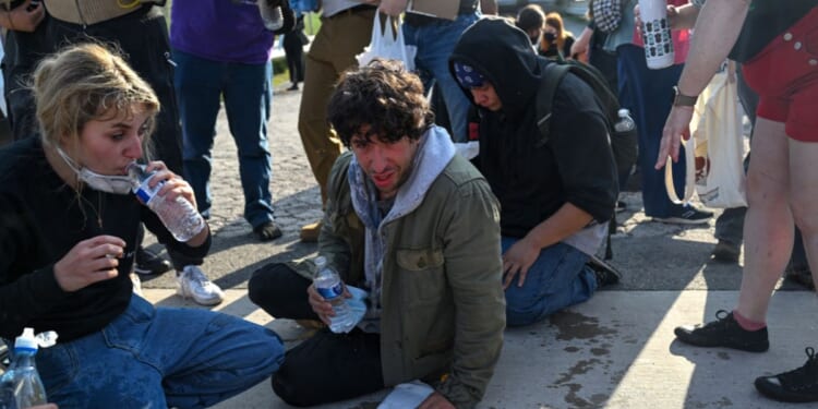 Demonstrators protesting outside a U.S Immigration and Customs Enforcement facility, including Democratic congressional candidate Kat Abughazaleh, left, react after being tear-gassed on Sept. 19, 2025, in Broadview, Illinois.