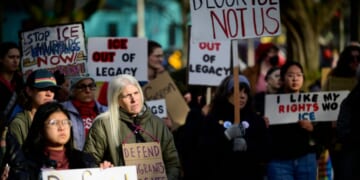 Anti-ICE activists display signs during a protest near Legacy Emanuel Hospital on Jan. 10, 2026, in Portland, Oregon.