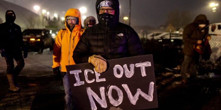 A protester holding an anti-ICE Sign standing outside the Henry Bishop Whipple Federal building on Jan. 18, 2026 in Minneapolis, Minnesota.