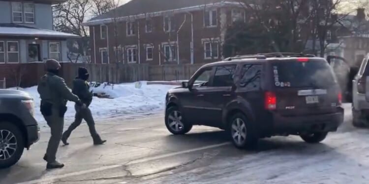 The officers are seen approaching the vehicle to confront the driver.