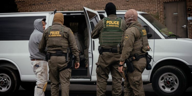 People detained earlier in the day are taken to a parking lot on the far north side of the city before being transferred to an Immigration and Customs Enforcement facility on Oct. 31, 2025, in Chicago, Illinois.