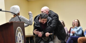 A man is tackled after spraying an unknown substance at Rep. Ilhan Omar during a town hall she was hosting in Minneapolis, Minnesota, on Jan. 27, 2026.