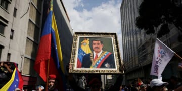 A man holds a portrait of Nicolas Maduro during a march in his support and his wife Cilia Flores after their capture by U.S. forces, on Jan. 6, 2026, in Caracas, Venezuela.