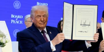 President Donald Trump holds up his signature on the founding charter during a signing ceremony for the “Board of Peace” at the World Economic Forum on Jan. 22, 2026, in Davos, Switzerland.