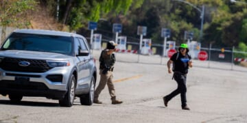 A federal agent gestures toward a National Lawyers Guild legal observer attempting to record license plates near Gate E of Dodger Stadium during a brief confrontation on June 19, 2025, in Los Angeles, California.