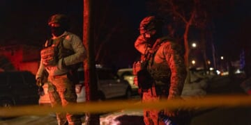 Two federal agents guard a perimeter following a shooting in Minneapolis, Minnesota, on Jan. 14, 2026.