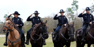 Police on horseback salute as the hearse carrying the flag-draped casket of former President George H.W. Bush heads to the Union Pacific train facility on Dec. 6, 2018, in Houston, Texas.