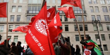 Members of the Democratic Socialists of America gather outside of a Trump-owned building on May Day on May 1, 2019, in New York City.