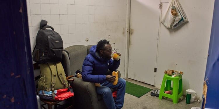 Yankuba Touray, from Gambia, eats his breakfast inside an abandoned school in Badalona, near Barcelona, Spain, on Dec. 16, 2025.