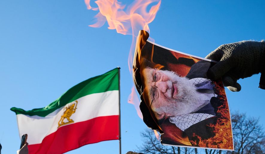 Protesters burn pictures of Iranian Supreme Leader Ayatollah Ali Khamenei as they march in support of regime change in Iran during a protest in Toronto, on Sunday, Feb. 1, 2026. (Sammy Kogan/The Canadian Press via AP)