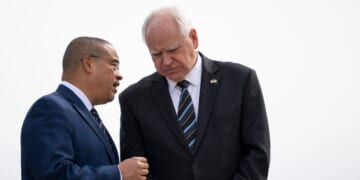 Minnesota Attorney General Keith Ellison and Minnesota Governor Tim Walz await the arrival of Vice President Kamala Harris at the Minneapolis-St. Paul International Airport in Saint Paul, Minnesota, on March 14, 2024.
