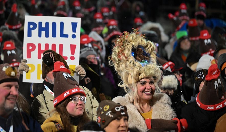 Toni Massey, of Bismack, N.D., right, celebrates while waiting for Punxsutawney Phil, the weather prognosticating groundhog, to come out and make his prediction during the 140th celebration of Groundhog Day on Gobbler's Knob in Punxsutawney, Pa., Monday, Feb. 2, 2026. (AP Photo/Barry Reeger)